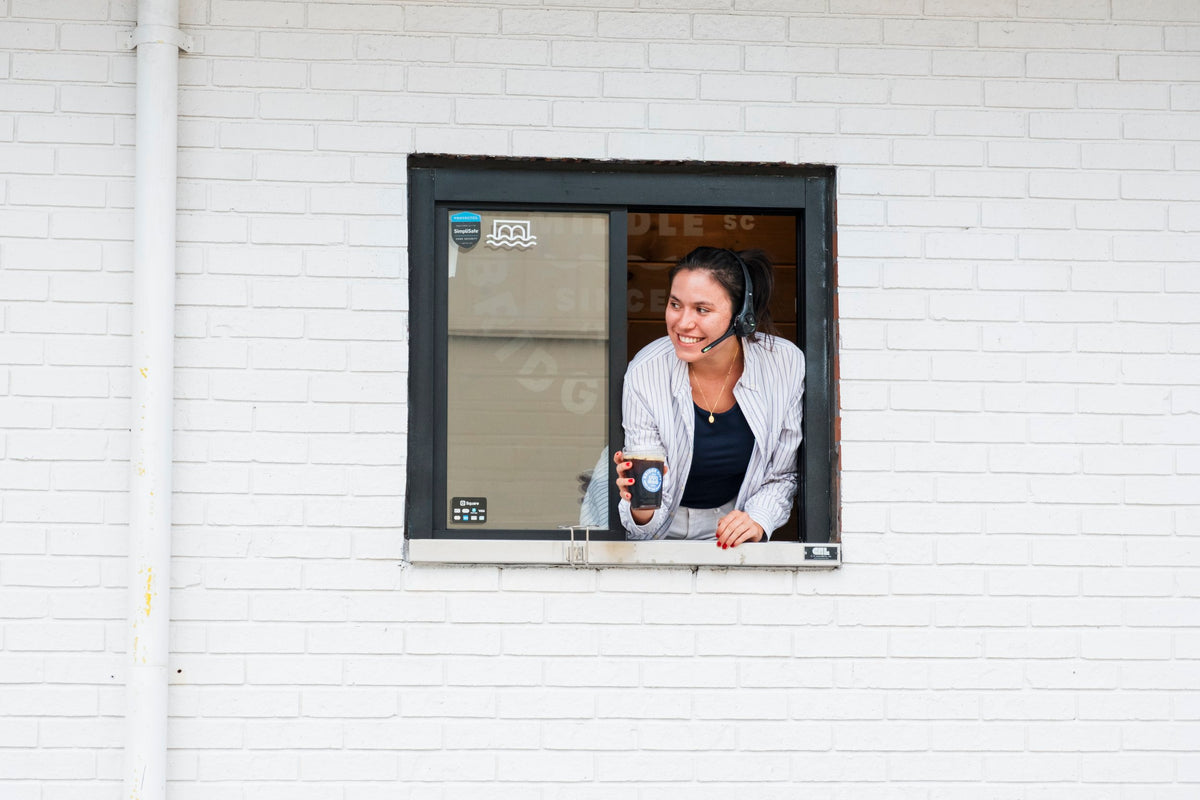 Woman at a drive through window  at Bridge City Coffee Shop